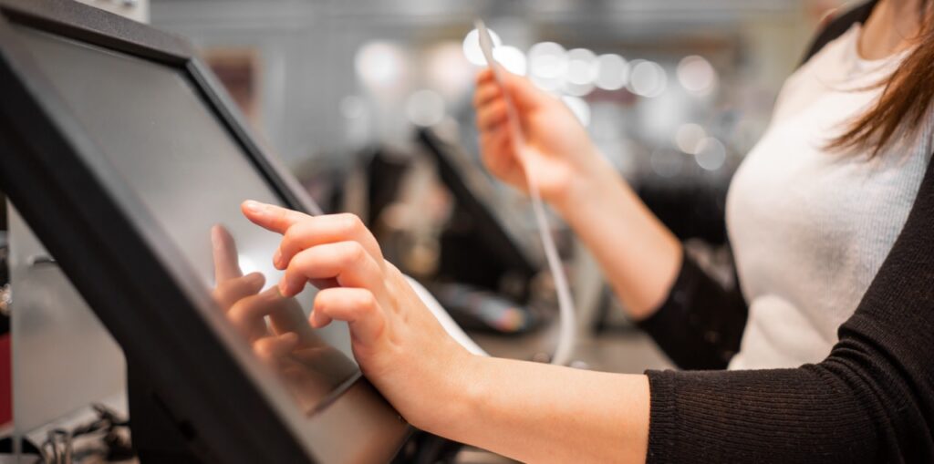 Retail cashier using FlexRetail POS loyalty integration to apply reward points, personalized promotions, and customer purchase history at checkout