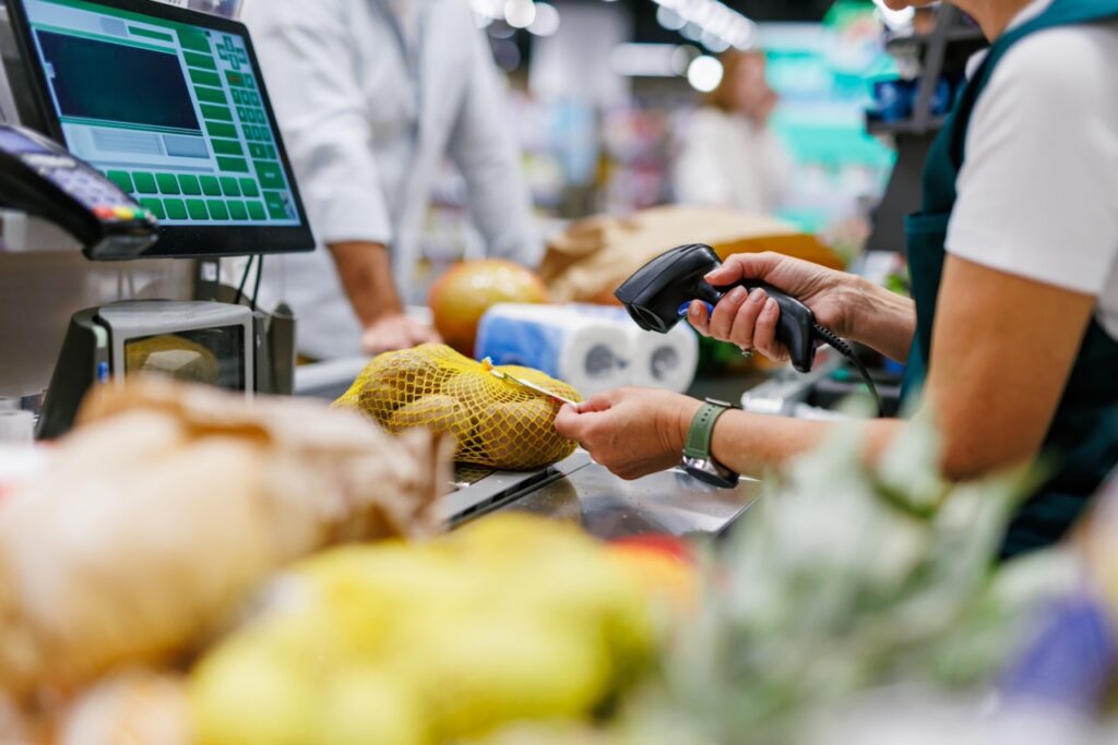 Grocery store manager reviewing POS transaction data to identify internal theft patterns and shrink anomalies