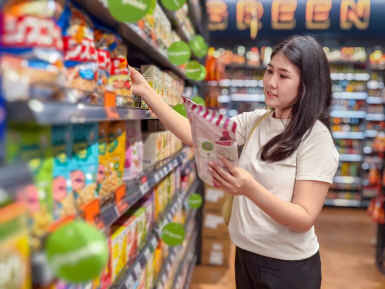 Cashier at a specialty ethnic grocery store using FlexRetail multilingual POS system to process EBT, Alipay, and WeChat Pay transactions with diverse product inventory