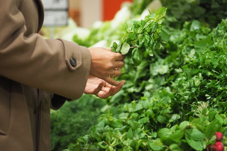 Natural foods co-op staff managing bulk inventory and member pricing at a grocery checkout counter