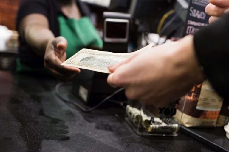A grocery checkout lane accepting both cash and contactless payment