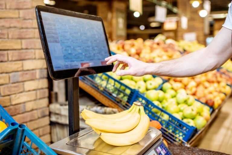 A grocery store team validating migrated customer and inventory data on a POS