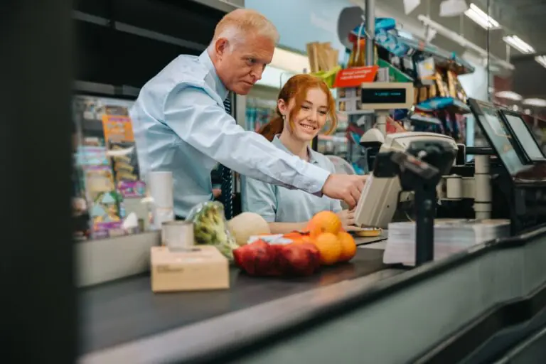 Grocery store manager reviewing weekly sales and margin reports on a point of sale dashboard