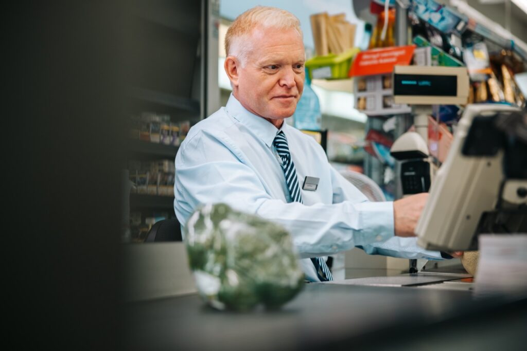 Grocery store owner analyzing price elasticity data during a period of inflation