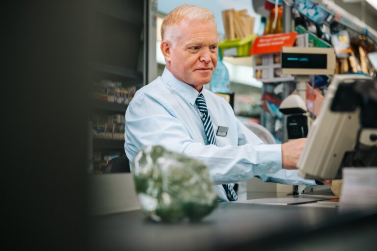 Grocery store owner analyzing price elasticity data during a period of inflation