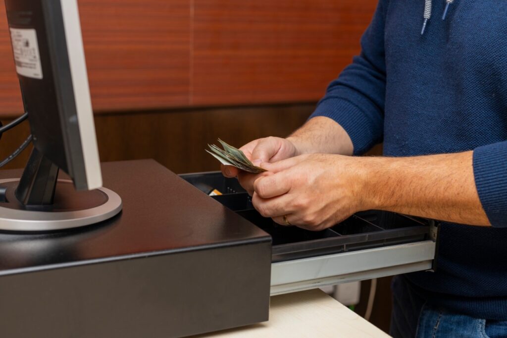 Grocery store manager performing a blind drawer count reconciliation