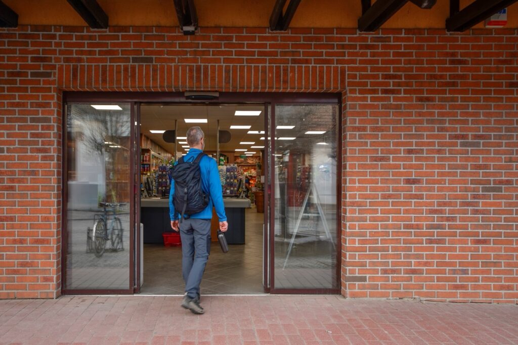 Shopper browsing a fresh produce display at the entrance of an independent grocery store