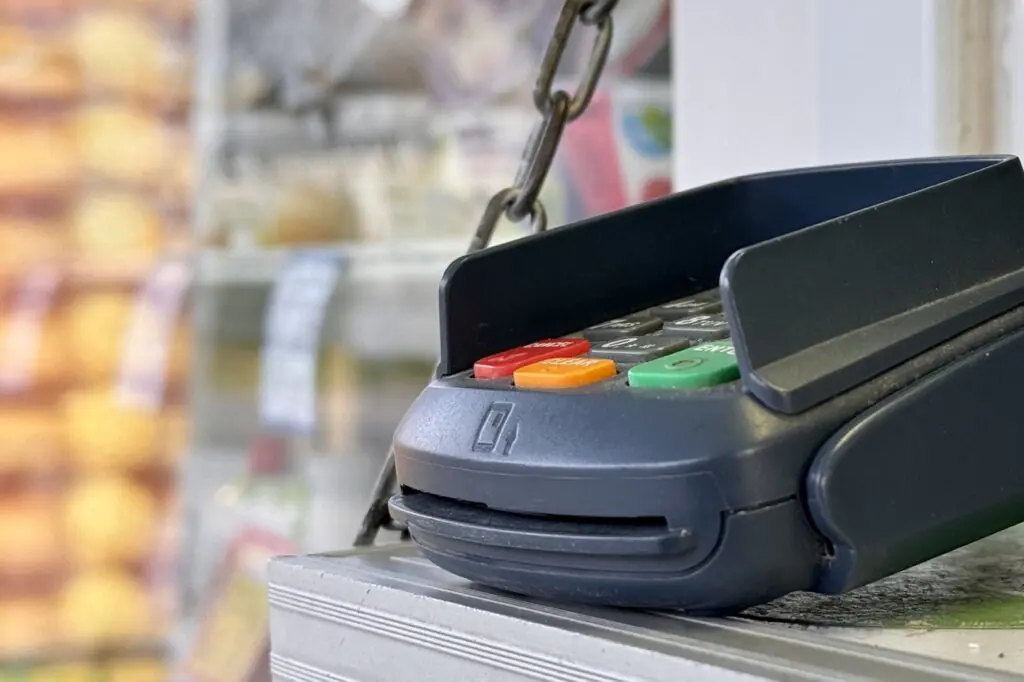 Grocery cashier reviewing a transaction with a customer to resolve a payment dispute