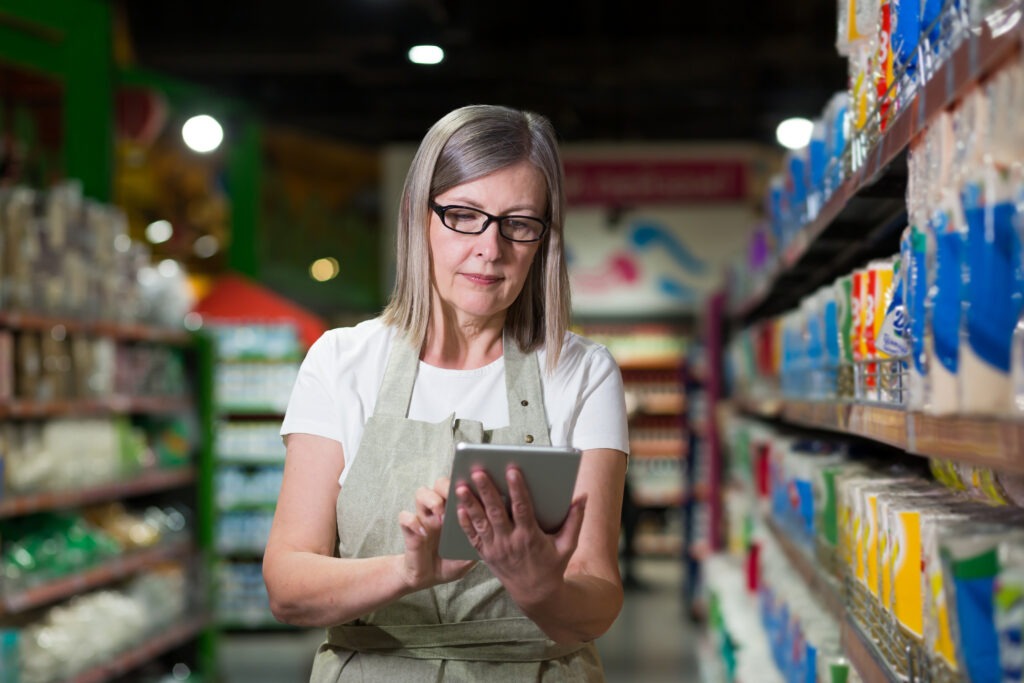 Grocery store manager reviewing cashier transaction speed and void rate data on a POS dashboard