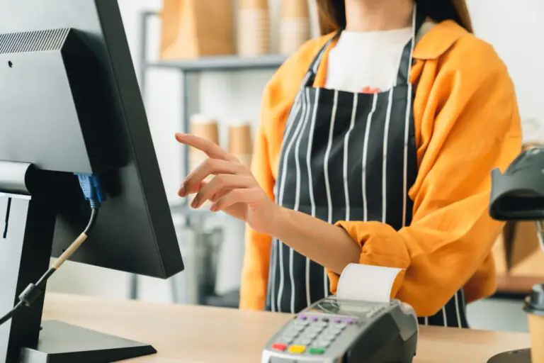 Grocery staff member using a POS terminal during grocery store cross-training