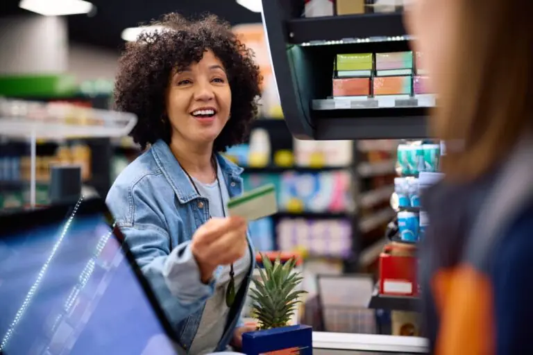 Grocery cashier processing an EBT split tender transaction at the register