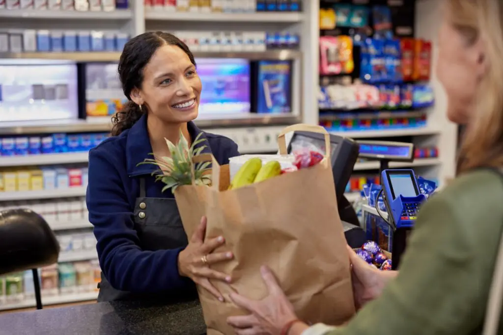 Grocery cashier checking eWIC eligibility for a customer at checkout